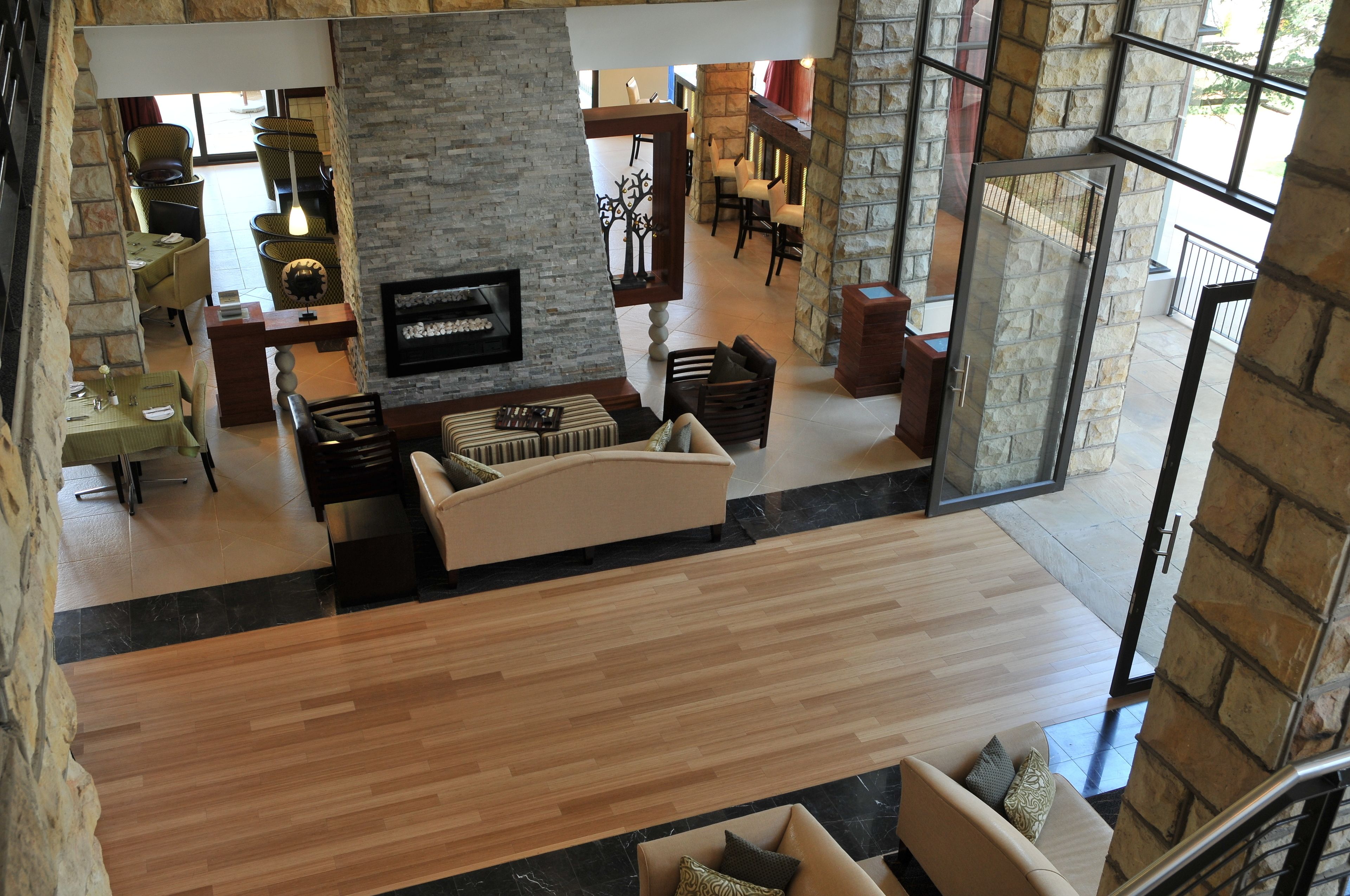 A spacious lobby with a stone wall, a fireplace, and a seating area with sofas and chairs.