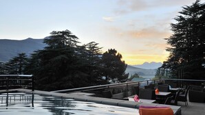 Uma área de piscina ao ar livre com assentos e vista para montanhas.