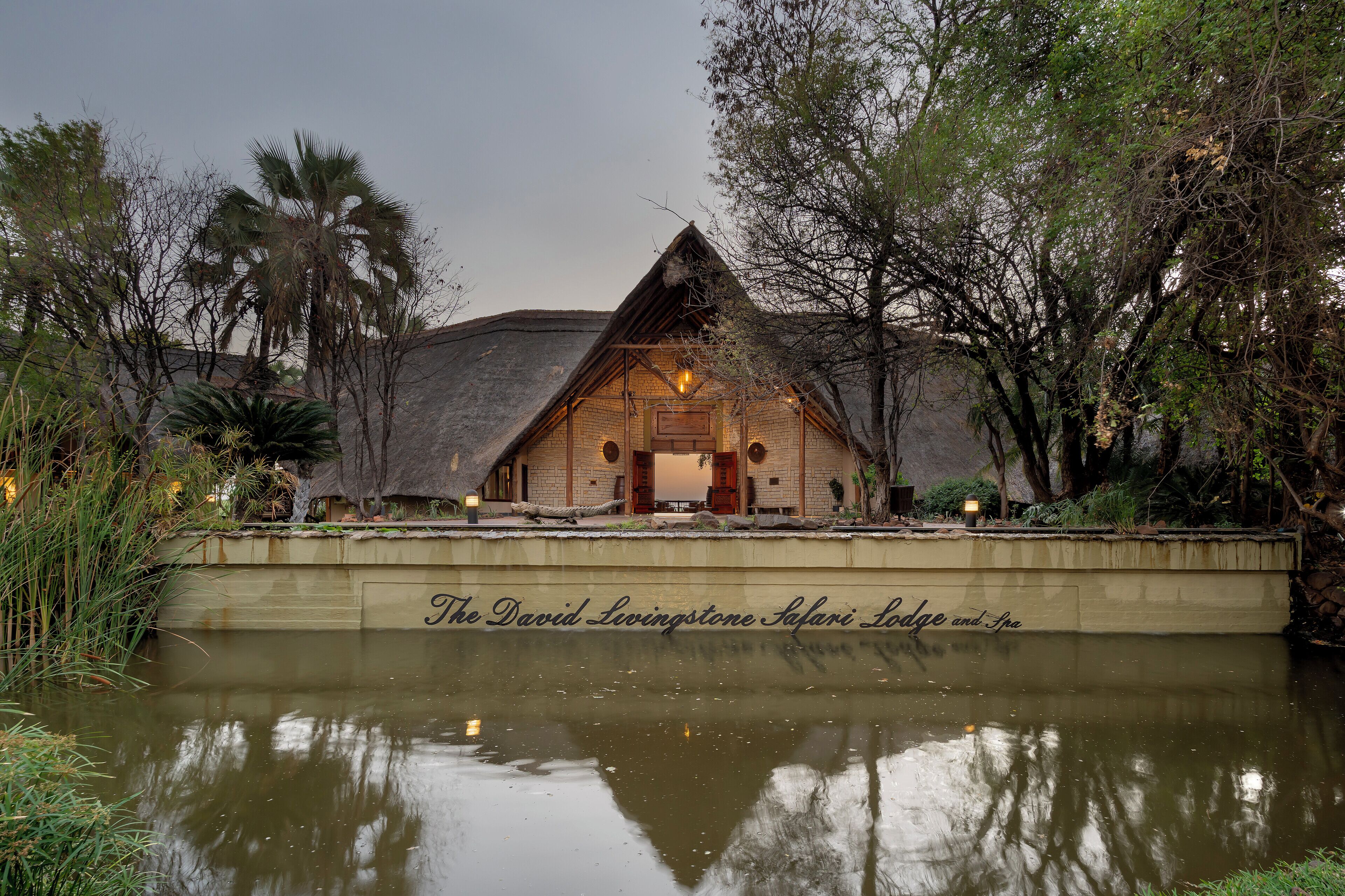 A building with a thatched roof and a sign reading "The David Livingstone Safari Lodge and Spa".
