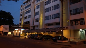 A multi-story hotel with a modern design, featuring a central column, multiple balconies, and a covered parking area. - Kapila Business Hotel (Pune)