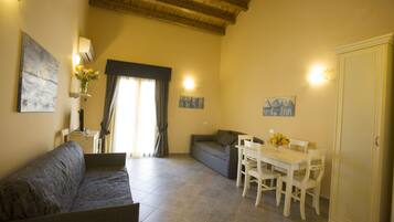 Suíte estúdio conforto, sacada, vista para a cidade | Área de estar | TV de tela plana 21 polegadas com canais via satélite, TV