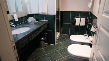 A bathroom with a sink, toilet, and shower area.
