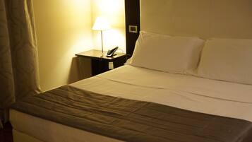 Ein Hotelzimmer mit Bett, Nachttisch mit Lampe und Telefon.