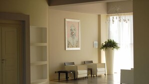 Una habitación con un ventanal amplio, un cuadro en la pared y dos sillas.