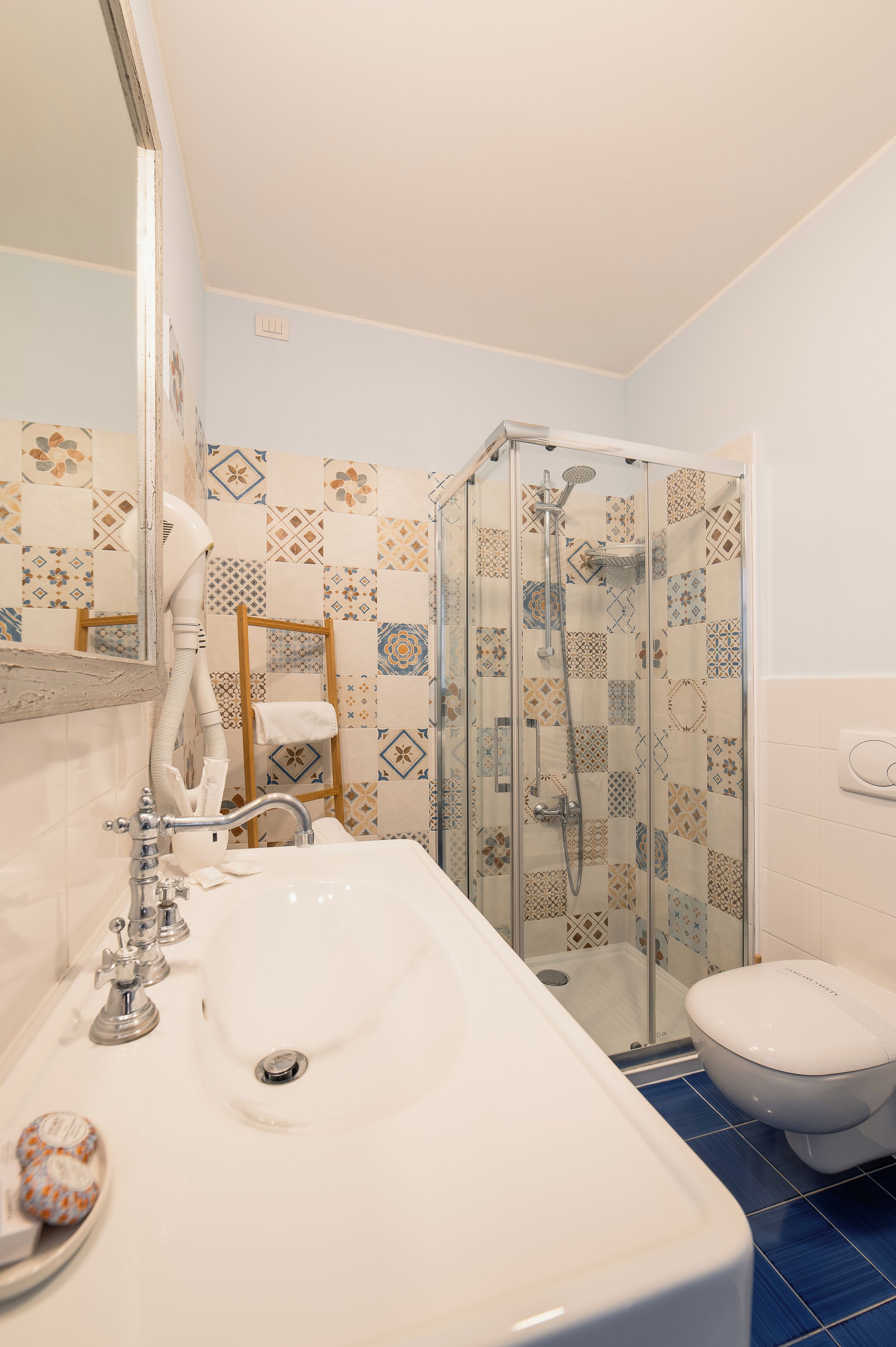 A bathroom with a glass-enclosed shower, a sink with a mirror, and a toilet.