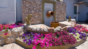 A stone building with a door and a water feature. - Paradice Hotel Luxury Suites (Chania)