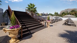 A staircase leading to a beach area with lounge chairs and umbrellas. - Paradice Hotel Luxury Suites (Chania)