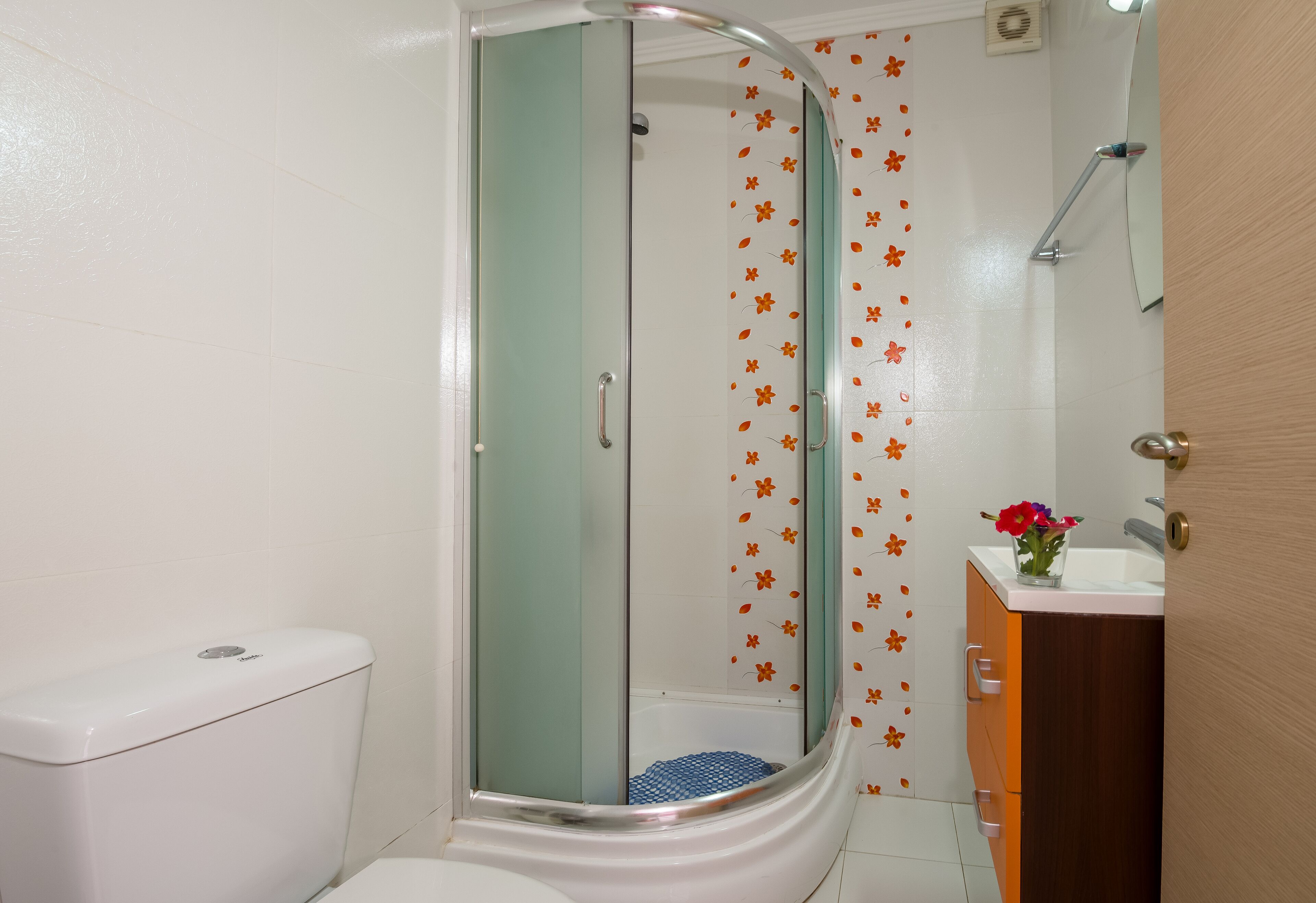A bathroom with a shower, toilet, and sink.
