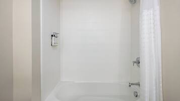 A white bathtub with a showerhead and a faucet.
