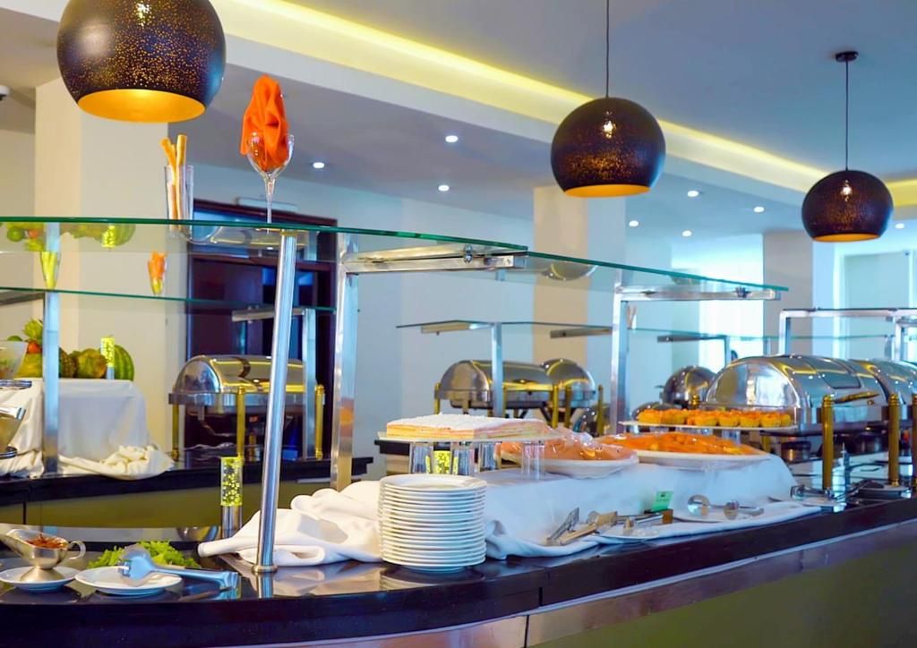 A buffet setup with various food items, glassware, and a glass railing.