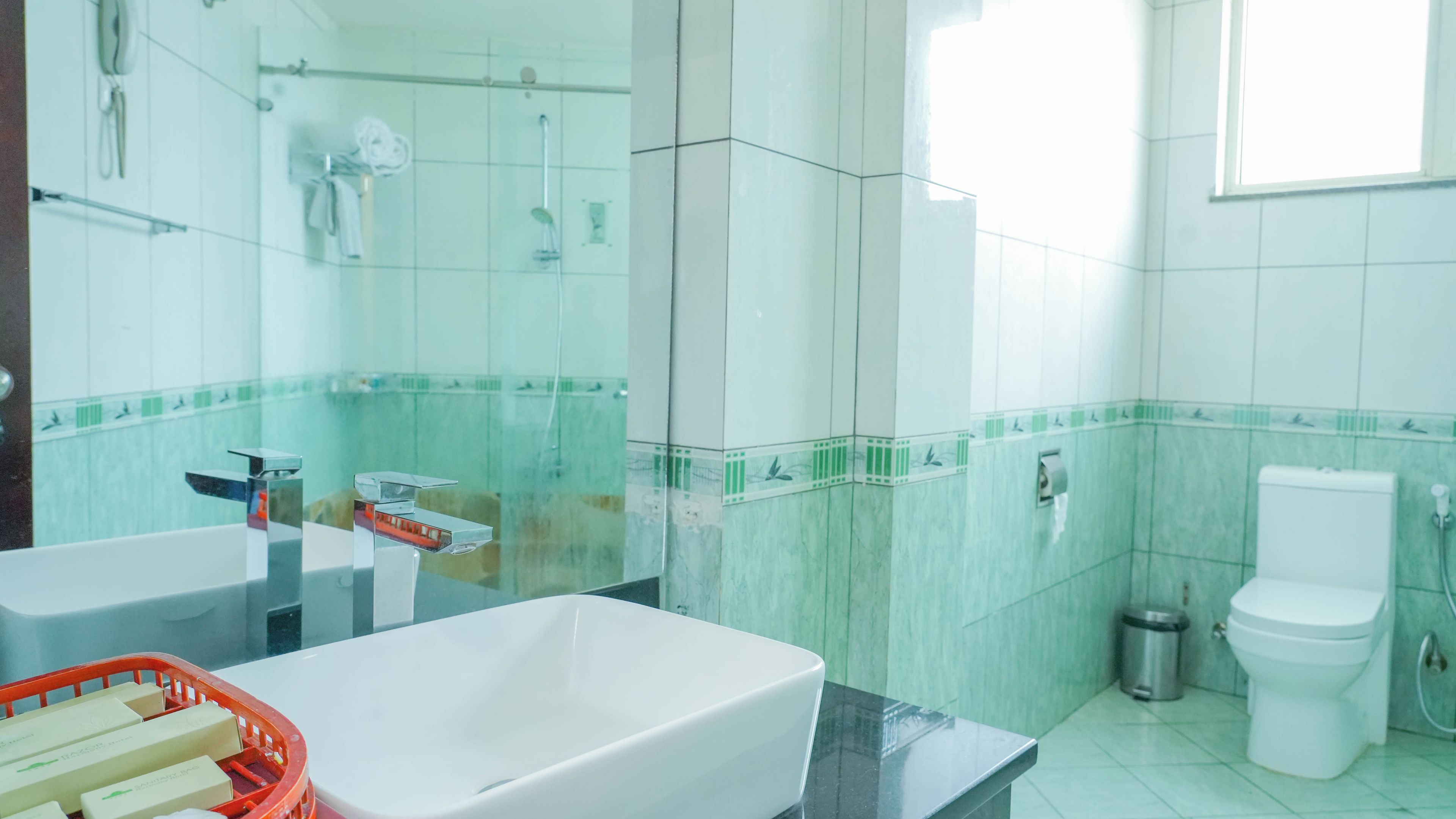 A bathroom with a white sink, a toilet, and a shower area.