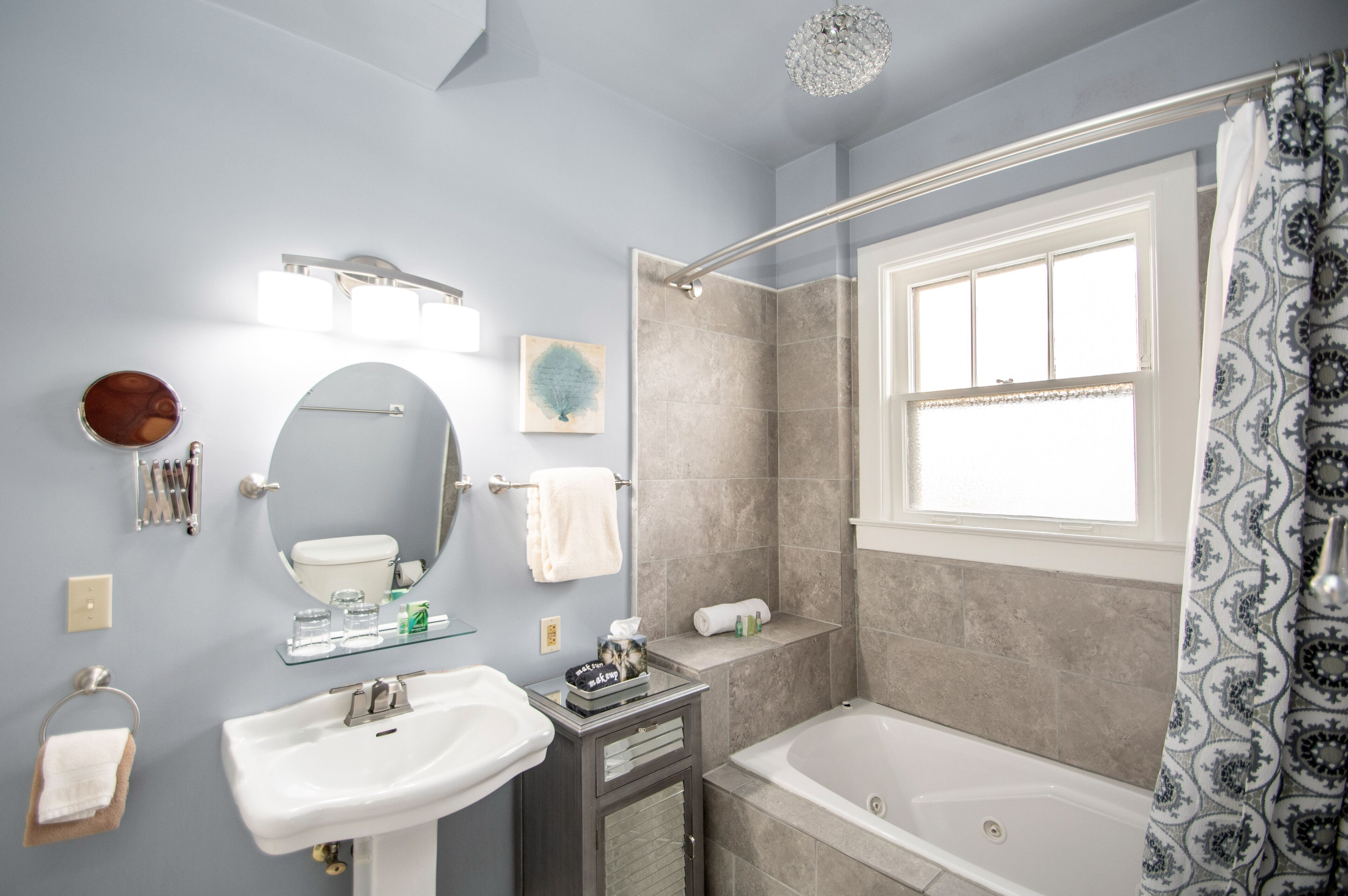 Een moderne badkamer met een bad, douche, wastafel en badkamermeubel.