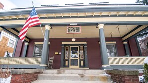 A building with a porch, a flag, and a sign that reads "Looking Glass Inn". - Looking Glass Inn (Indianapolis)