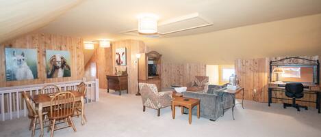 A spacious loft with a dining area, seating, and a workspace.