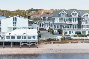A waterfront property with a dock, multiple-story houses, and a white picket fence. - Prince Albert Provincetown (Provincetown)