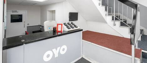 A reception desk with a sign for 'Tulsi Apartment' and a website address.