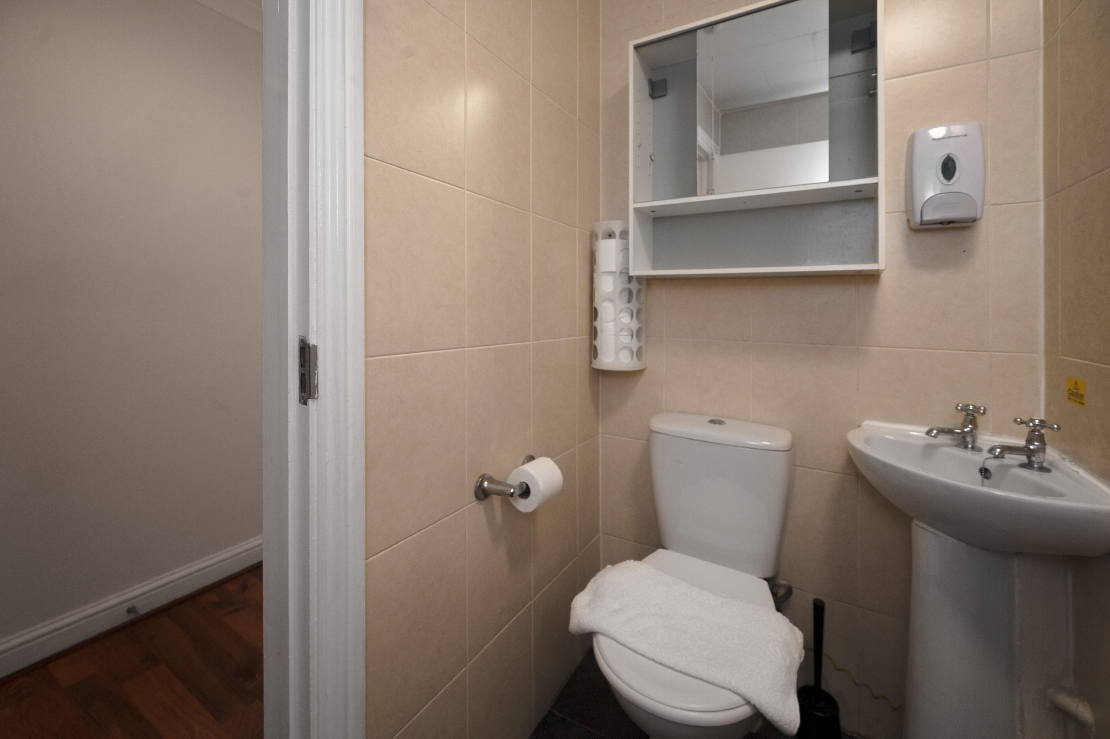 A bathroom with a toilet, sink, and a mirror.