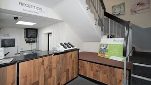 A reception area with a sign for 'Tulsi Aparthotel' and a 'Self Check-in' sign. - Flexistay Tulsi Aparthotel (Croydon)