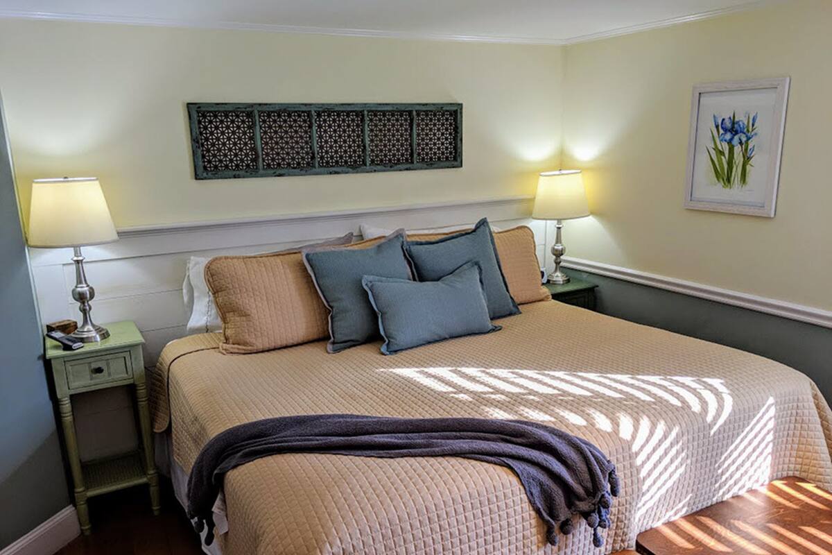 A neatly arranged bedroom with a large bed, two bedside tables, and a nightstand.