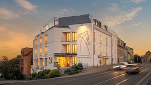 A modern building with a large mural, multiple floors, and a well-lit facade. - Hotel Troja (Prague)