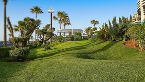 Villa Blanca with a well-manicured lawn, palm trees, and a modern building structure.