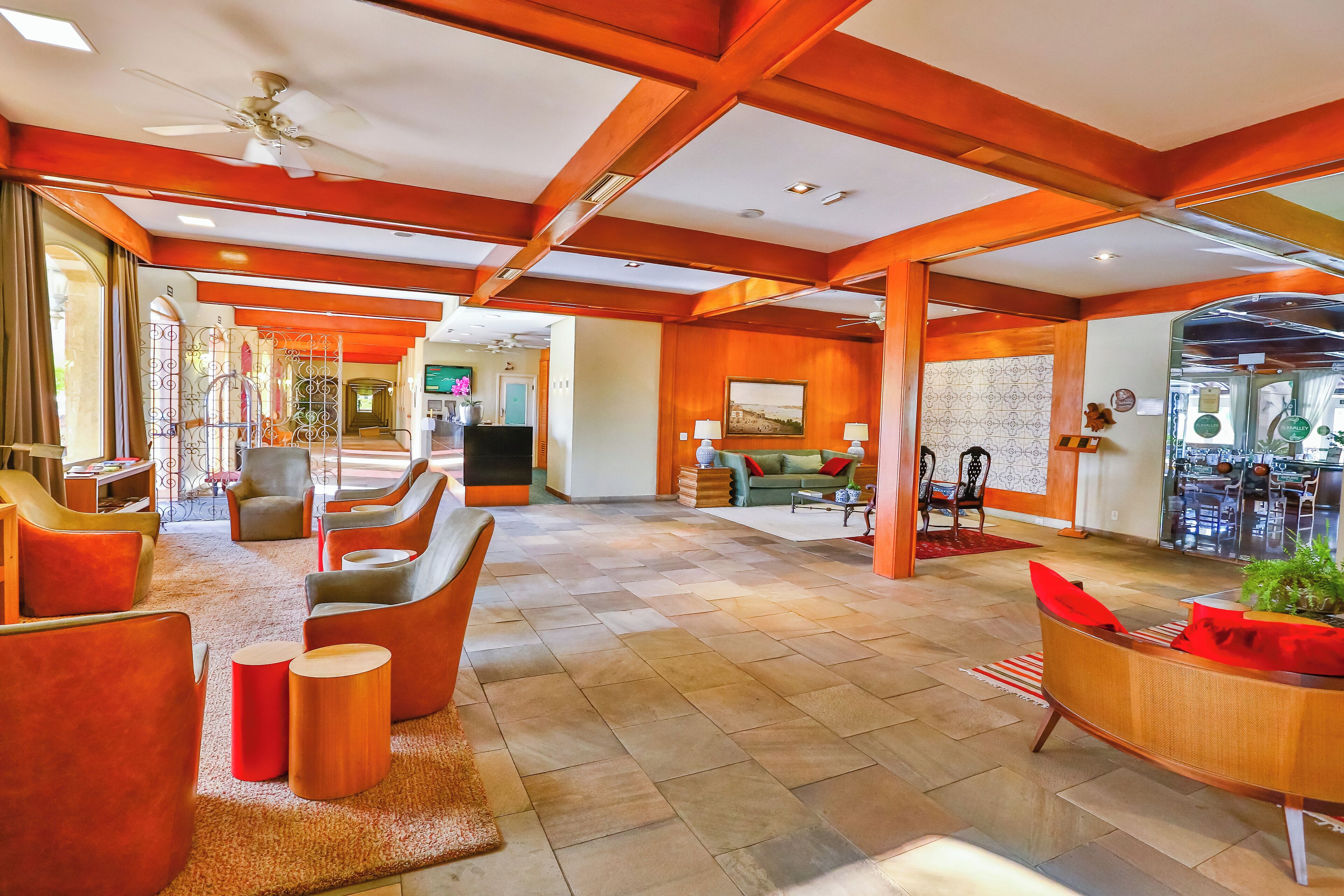 A spacious lobby with modern furniture, a ceiling fan, and a view into the dining area.