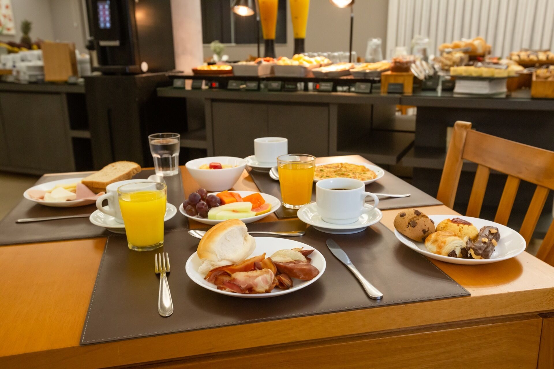 Ein reichhaltiges Frühstücksbuffet mit einer Auswahl an Speisen, darunter Gebäck, Früchten und Getränken.