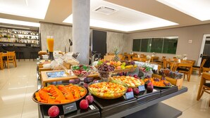 Un bufé con diversas frutas y verduras, incluyendo zanahorias, manzanas y uvas.