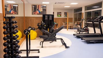A gym with exercise equipment including treadmills, a bench press, and a squat rack.