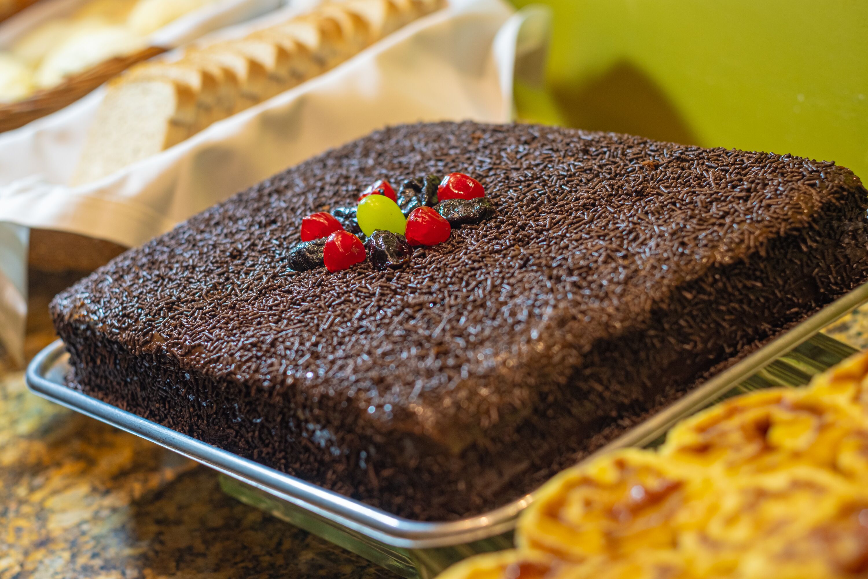 A chocolate cake with toppings on a tray.