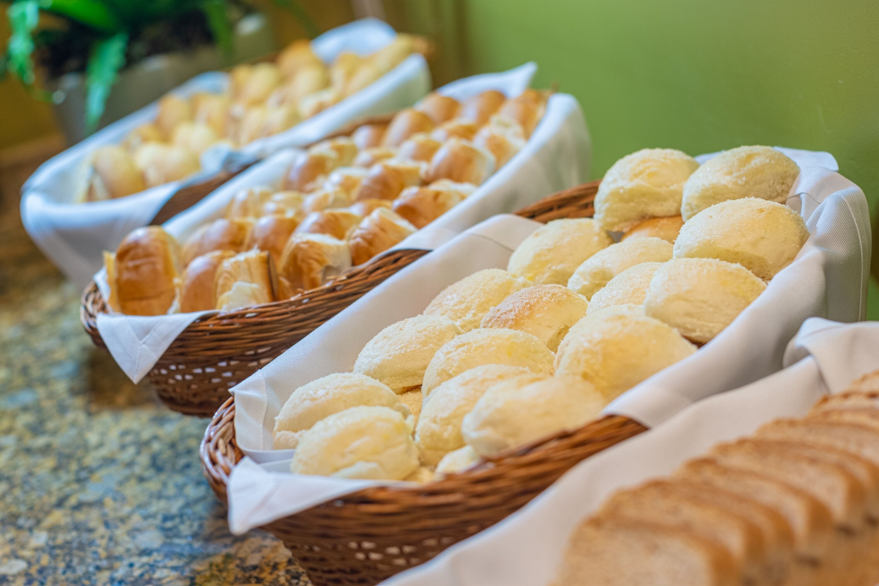 A buffet with various baked goods, including bread and pastries, arranged on a table.