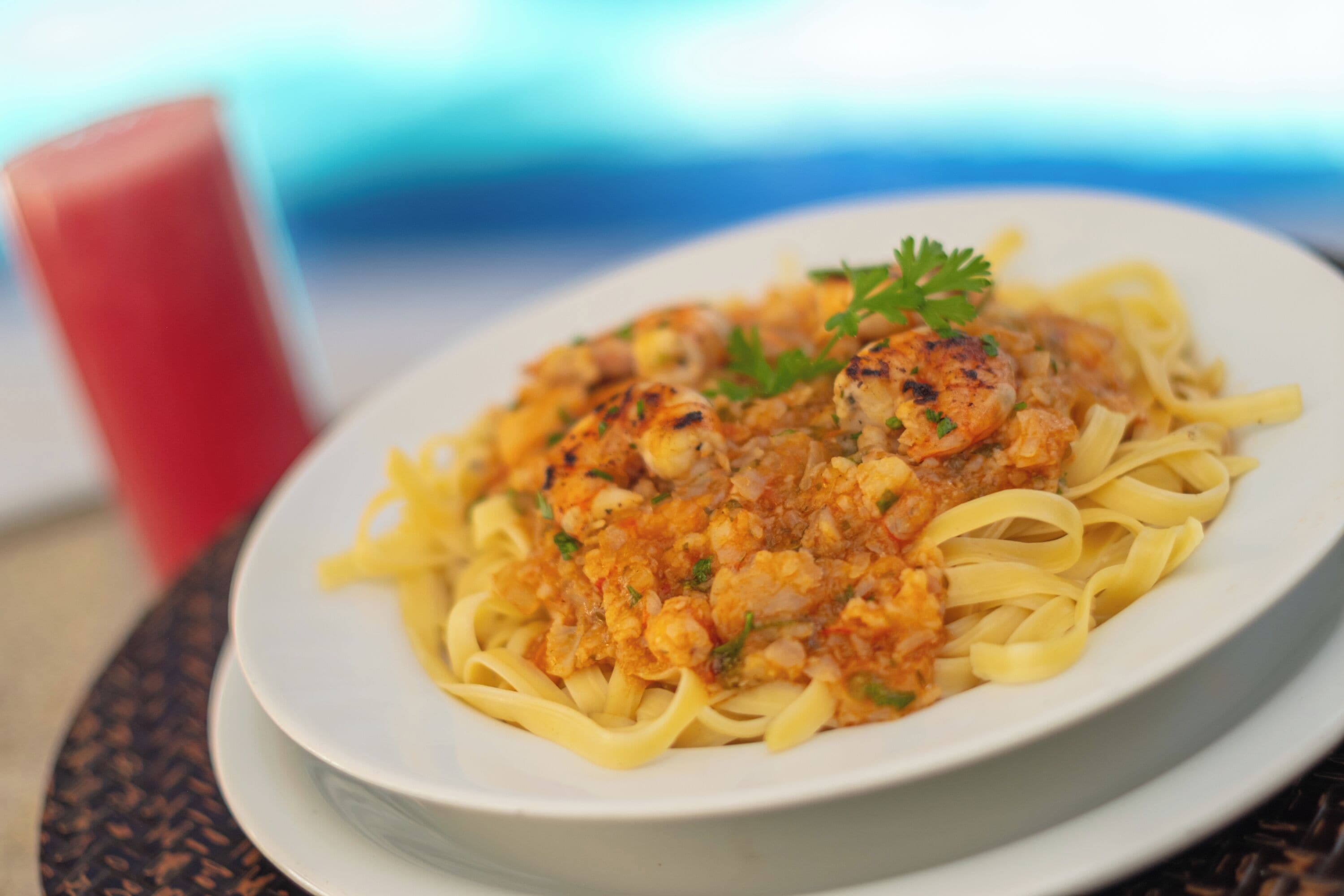 Un plato de pasta con salsa cremosa y adornado con perejil, servido en un plato blanco.