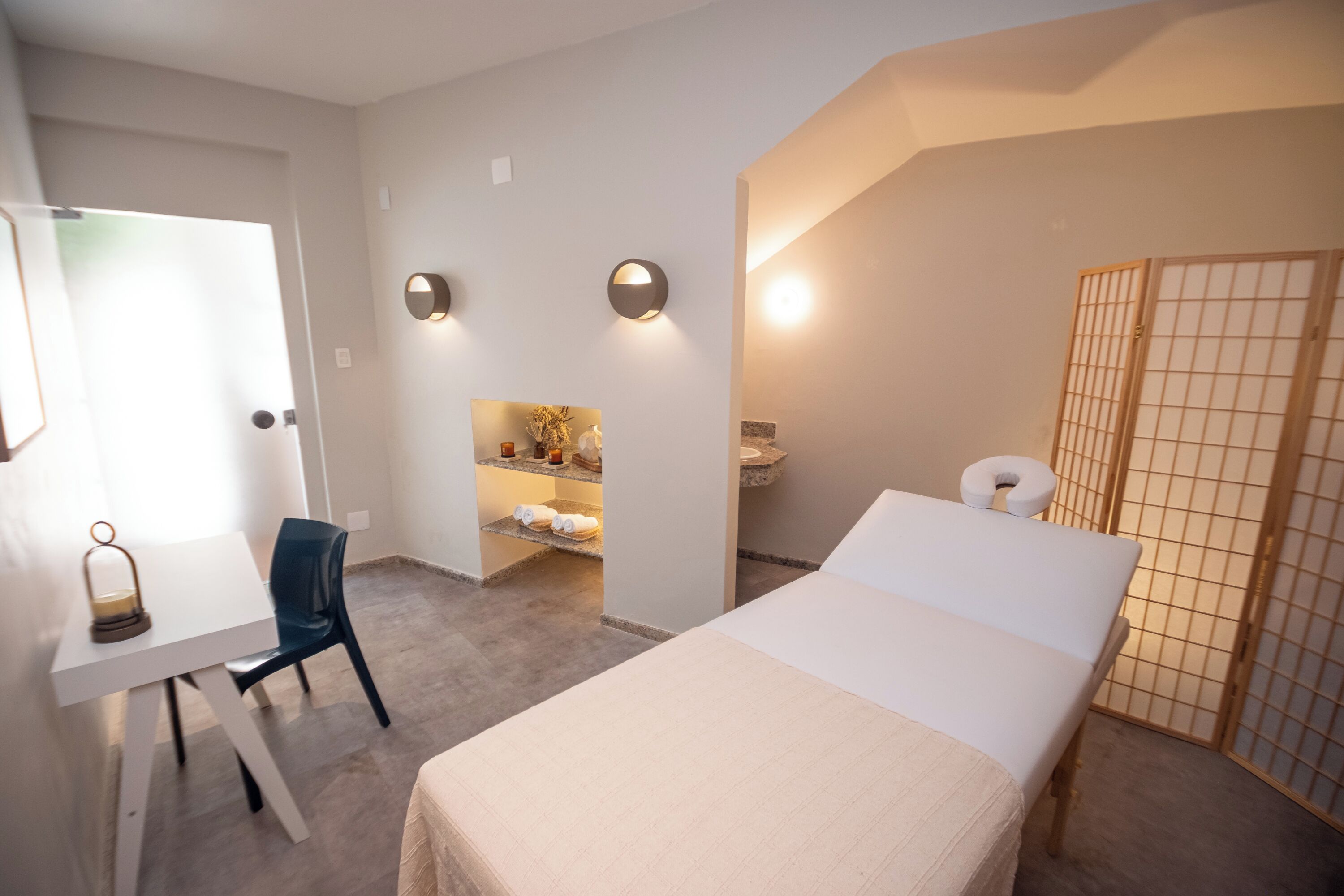 Habitació d'hotel amb llit, escriptori, cadira, bany petit i vàter.