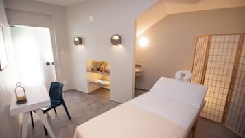 Habitació d'hotel amb llit, escriptori, cadira, bany petit i vàter.