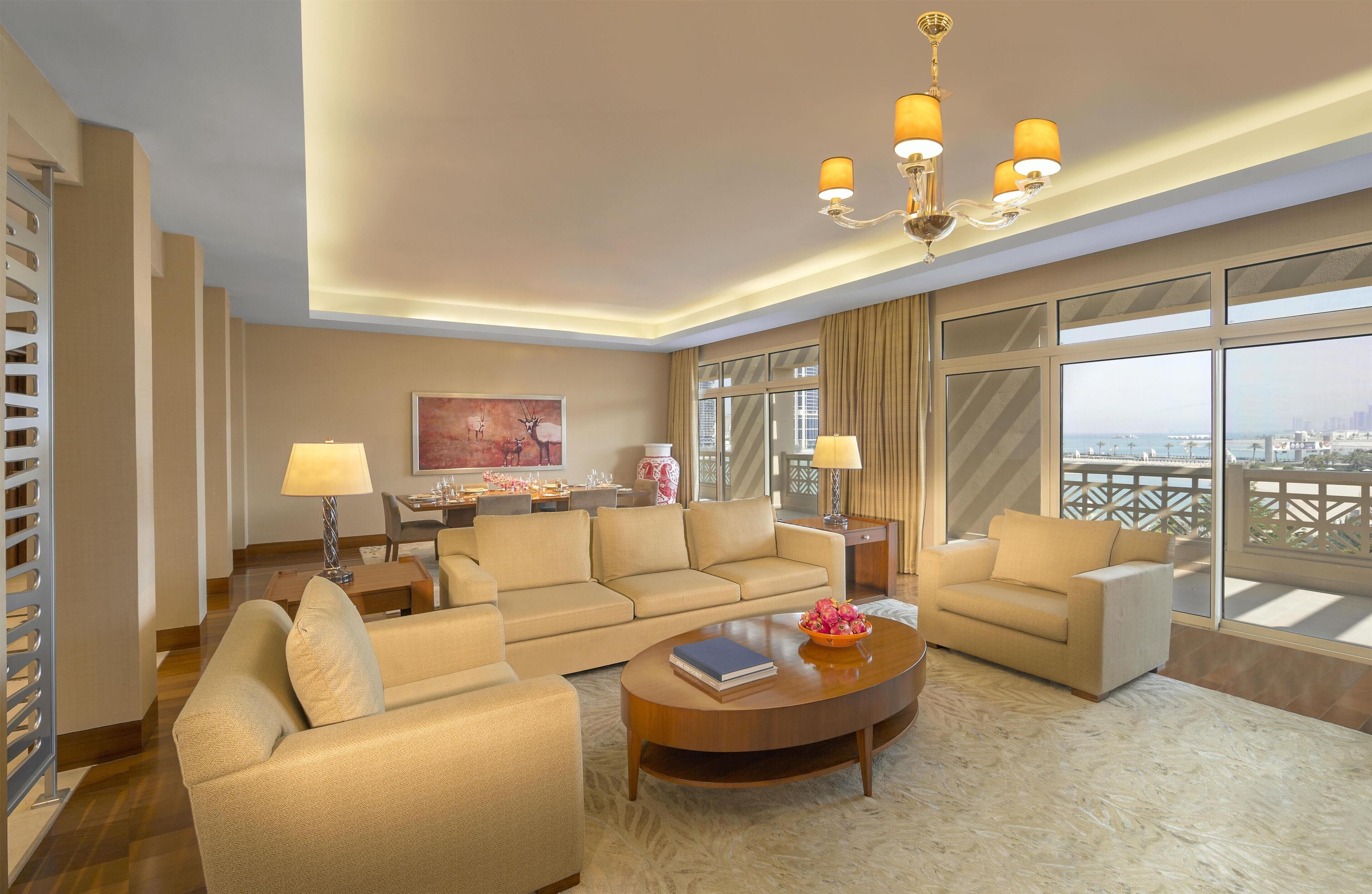 A spacious living room with a sofa set, a coffee table, and a chandelier.