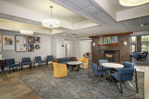 A modern lobby with seating areas, a fireplace, and artwork on the walls. - Homewood Suites by Hilton Phoenix North-Happy Valley (Phoenix)