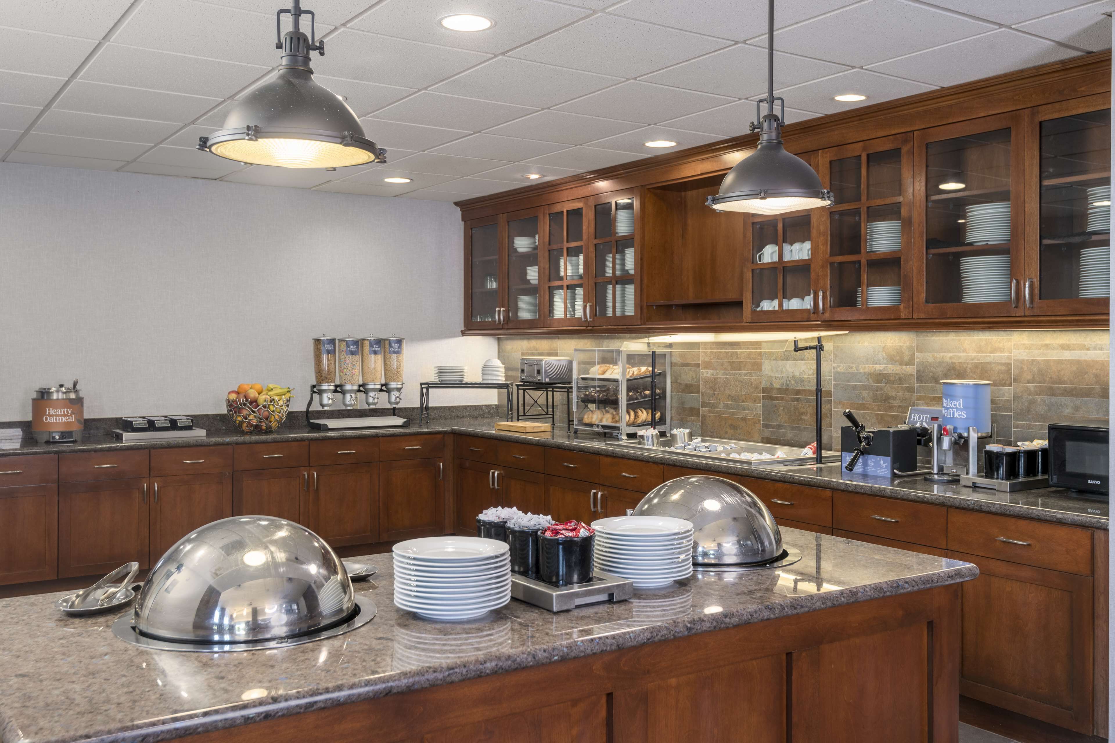 A modern kitchen with granite countertops, stainless steel appliances, and wooden cabinets.