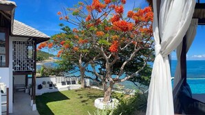 A view from a room with a window overlooking a pool and the sea. - Kanda Residences Pool Villas (Koh Samui)