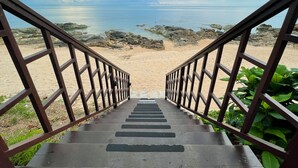 A staircase leading to a beach with a view of the ocean and rocky shoreline. - Kanda Residences Pool Villas (Koh Samui)