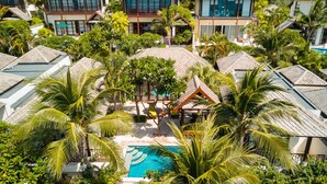 A resort with multiple villas, a central pool, and lush tropical vegetation. - Kanda Residences Pool Villas (Koh Samui)