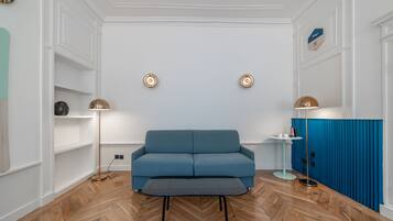 Un saló modern amb un sofà blau, una taula de centre i un moble blau.