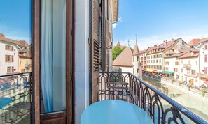 A balcony with a view of a river and buildings. - Hôtel du Palais de l'Isle (Annecy)