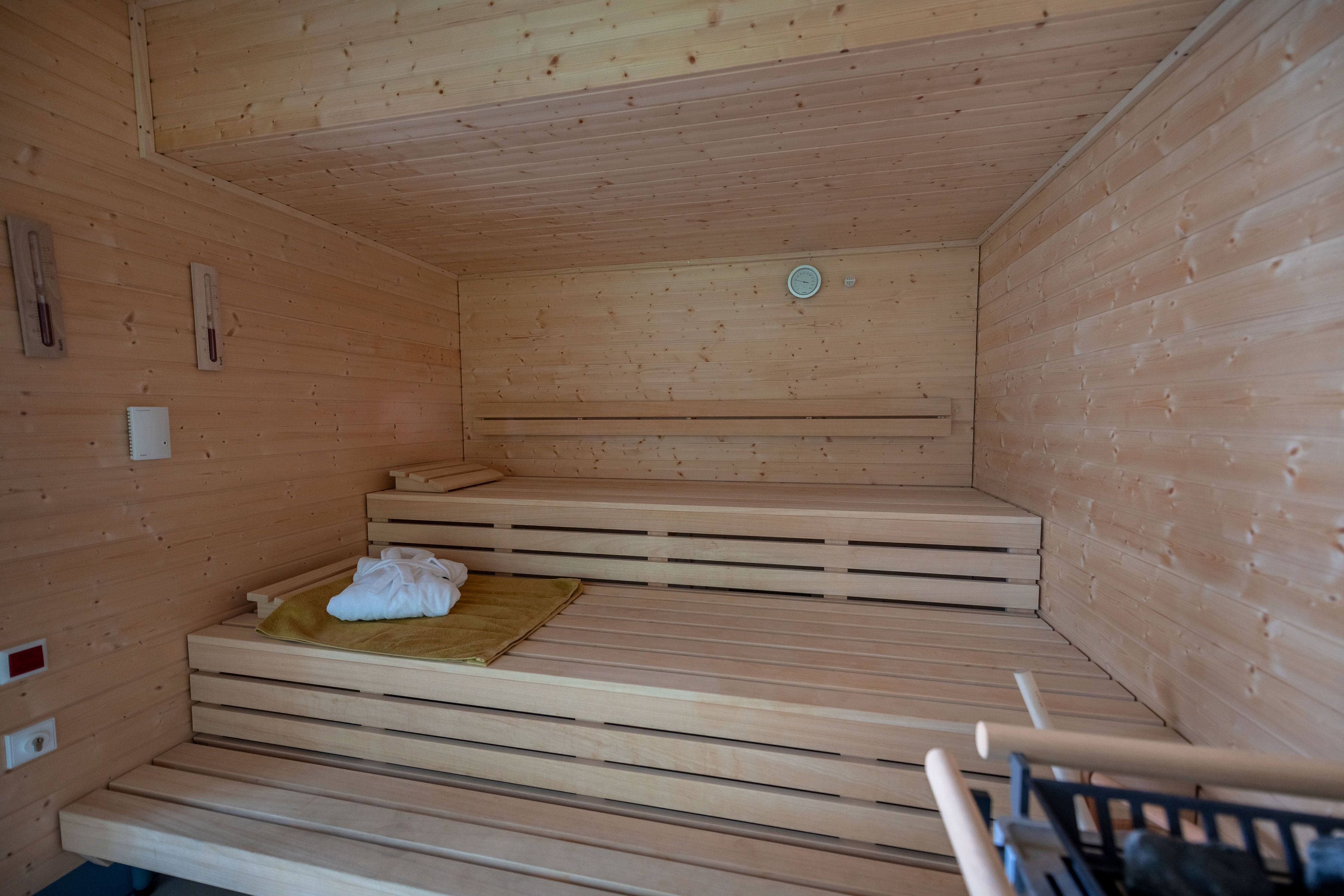 Eine Sauna mit Holzbänken und einer Bank mit Handtuch.