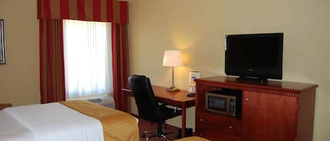 Una habitación de hotel con dos camas, un escritorio con silla, un televisor y un microondas.