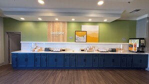 A breakfast bar with a sign reading "Delight in the day," equipped with various breakfast items and a coffee machine. - Spark by Hilton Brandon (Brandon)