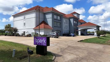 Welcome to Spark by Hilton, where a covered driveway and beautifully manicured lawn greet guests.
