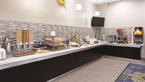 A modern breakfast bar with a tiled backsplash, coffee machines, and a variety of food options. - La Quinta Inn & Suites by Wyndham San Antonio Northwest (San Antonio)