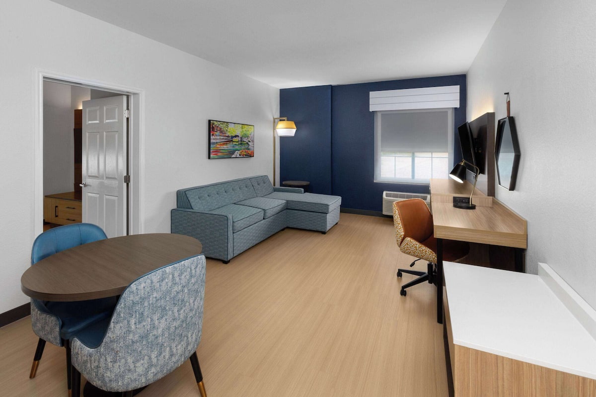 Un espace de vie compact comprenant un canapé, une table à manger et un espace de travail.