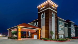 A hotel with a prominent 'La Quinta' sign, a covered entrance, and a parking lot.