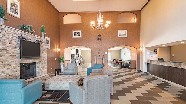 A spacious lobby with a stone fireplace, comfortable seating, a chandelier, and a check-in counter. - La Quinta Inn & Suites by Wyndham Glen Rose (Glen Rose)